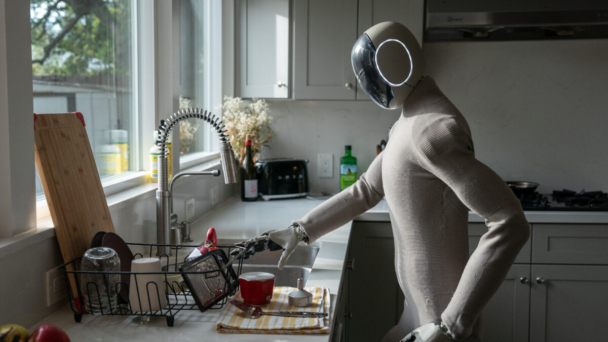 A NOI humanoid robot tidying a sunlit home kitchen